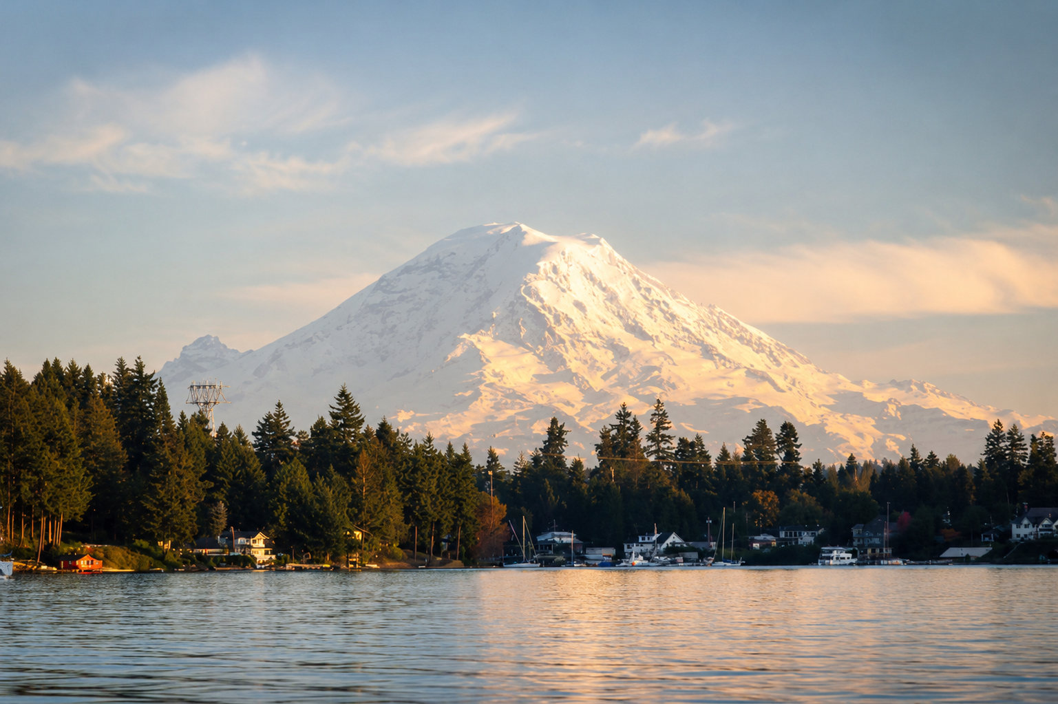 Mount Rainier rising above a Puget Sound waterfront community at golden hour